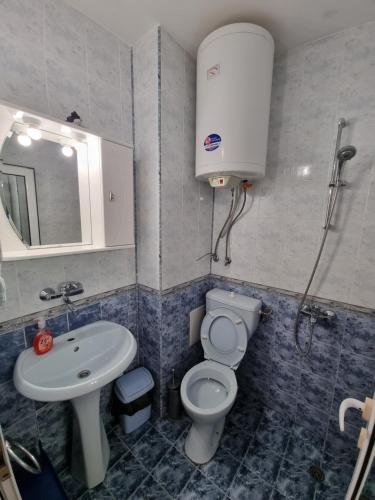 a bathroom with a toilet and a sink at Нашето място in Pomorie