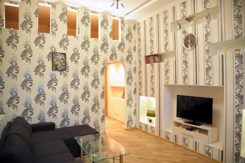 - un salon avec un canapé et une télévision dans l'établissement Apartment on Pushkinskaya 16, à Odessa