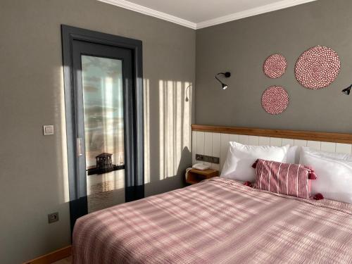 a bedroom with a bed with a pink blanket and a window at Istanbul Old City Colorful Houses Balat PETRION Hotel in Istanbul