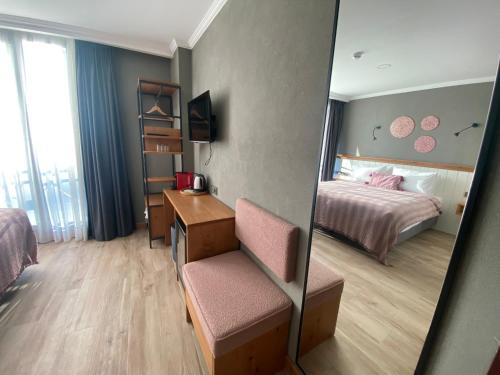 a hotel room with a bed and a desk and a mirror at Istanbul Old City Colorful Houses Balat PETRION Hotel in Istanbul