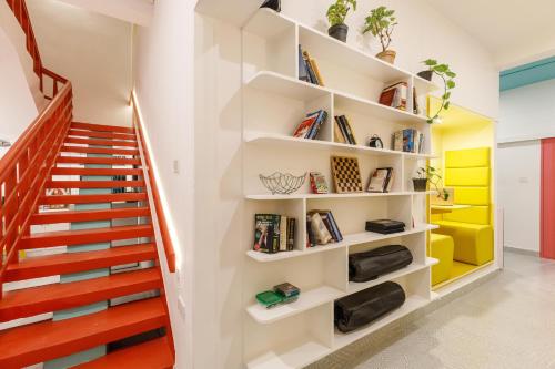 a staircase in a house with white walls and colorful shelves at Locul Midtown-Indiranagar in Bengaluru