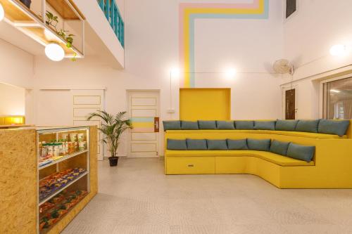 a room with a yellow couch in a store at Locul Midtown-Indiranagar in Bengaluru