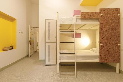 a room with a bunk bed with a ladder at Locul Midtown-Indiranagar in Bengaluru