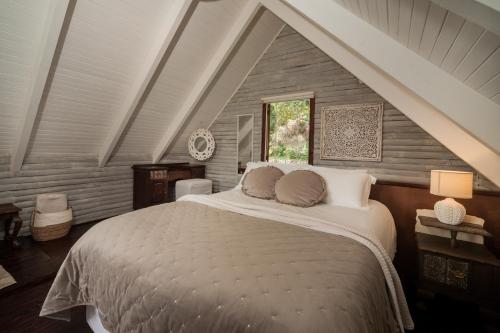 um quarto com uma cama grande num sótão em Viewpoint - Cabin 1 em Haenertsburg