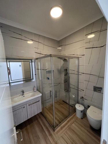 a bathroom with a shower and a toilet and a sink at Life Point Hotel in Çeşme