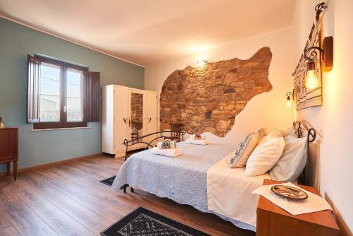 a bedroom with a bed and a brick wall at al VICOLO VI in Sardara