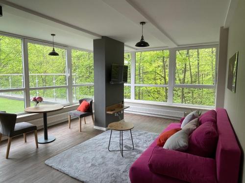 a living room with a purple couch and a table at Apartament Kurort Kozubnik - Taras nad Potokiem in Porąbka