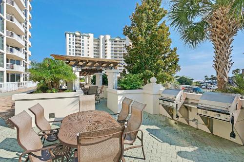 a patio with a table and chairs and a grill at St Lucia at Silver Shells in Destin