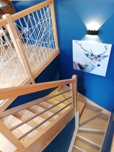 a staircase in a room with blue walls and a light fixture at Monchateau étoilé, hébergement insolite avec Spa in Merlas
