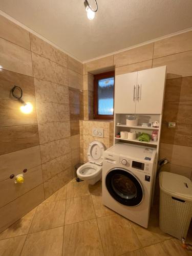 a bathroom with a washing machine and a toilet at Domček u Mirka in Dolný Kubín