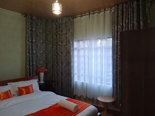 1 dormitorio con 1 cama y una ventana con cortinas en The kioka gardens with Wifi and parking en Nanyuki