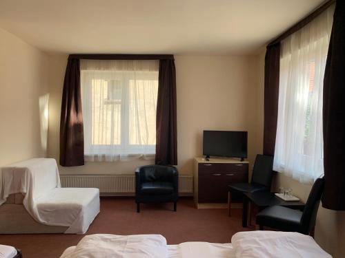 a hotel room with two beds and a window at City Hotel Agoston in Pécs