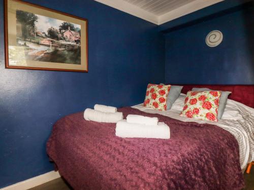 a blue room with a bed with towels on it at The Studio in Bodmin