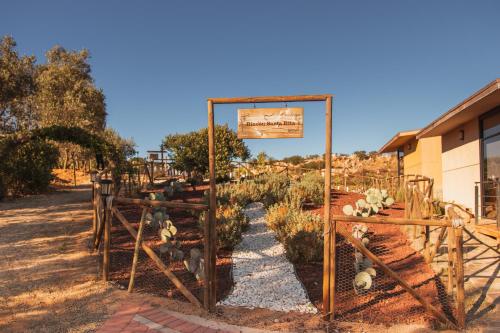 a garden with a sign and some plants at Brisa Del Valle Hotel Boutique in Valle de Guadalupe