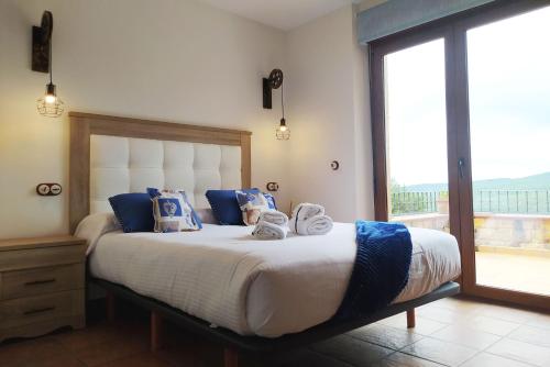 um quarto com uma cama grande e toalhas em Camino del Pinar em Quintanar de la Sierra