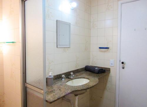 a bathroom with a sink and a mirror at Apto a 200 m da Praia das Pitangueiras-Guaruja SP in Guarujá