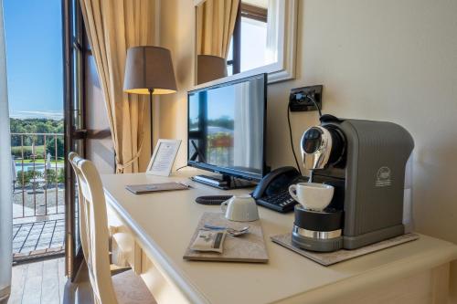 a desk with a coffee maker and a computer on it at Relais Bella Rosina Pool & Spa in Fiano