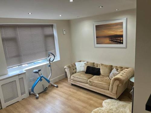 a living room with a couch and a window at Fabulous 3 bedroom house , sleeps up to 5-7 guest. in South Ockendon