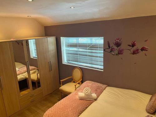 a bedroom with a bed with a flower sticker on the wall at Fabulous 3 bedroom house , sleeps up to 5-7 guest. in South Ockendon