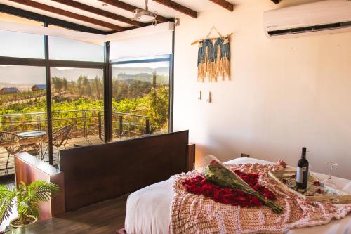 Schlafzimmer mit einem Bett und Blick auf einen Weinberg in der Unterkunft Brisa Del Valle Hotel Boutique in Valle de Guadalupe