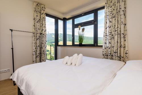 a bedroom with a large white bed and a window at Apartmán Dolce Vita Klínovec in Loučná pod Klínovcem