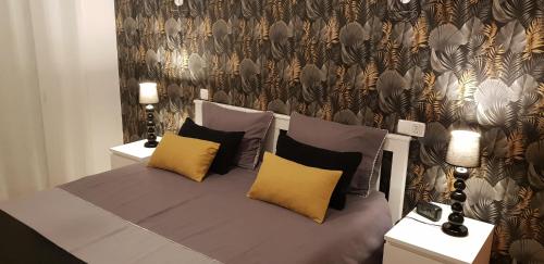 a bed with yellow and black pillows in a room at T2 Encosta sao jose guia albufeira in Albufeira