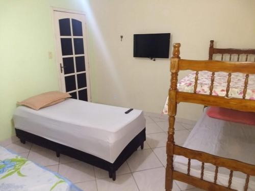 a bedroom with two bunk beds and a flat screen tv at Arraial do Cabo in Arraial do Cabo