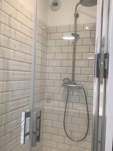 Un baño con ducha con puerta de cristal. en Trinquet Bordatxo, en San Juan de Luz