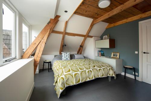 1 dormitorio con 1 cama en una habitación con techos de madera en Schitterend appartement in dorpsstraat Langweer!, en Langweer