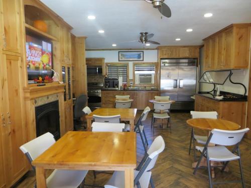 una cocina con mesas de madera y sillas blancas en Stardust Lodge en South Lake Tahoe