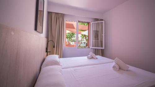 1 dormitorio con 2 camas blancas y ventana en Sant Joan Apartaments - Adults Only en Cala en Blanes