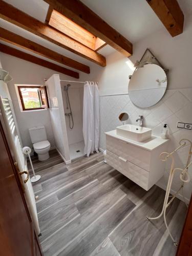 a bathroom with a sink and a toilet and a mirror at Cal Tio Lluc in Sóller
