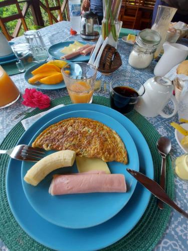 a blue plate with a breakfast of omelet and a banana at Eden Valley Ecolodge and Farming in Madalena