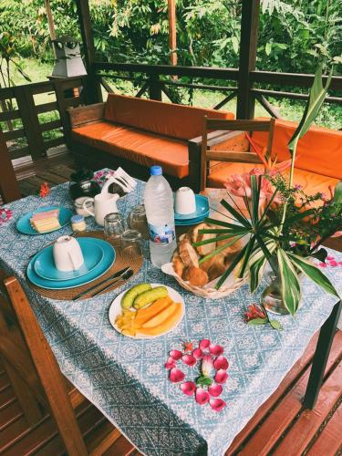 a table with a blue table cloth with food on it at Eden Valley Ecolodge and Farming in Madalena