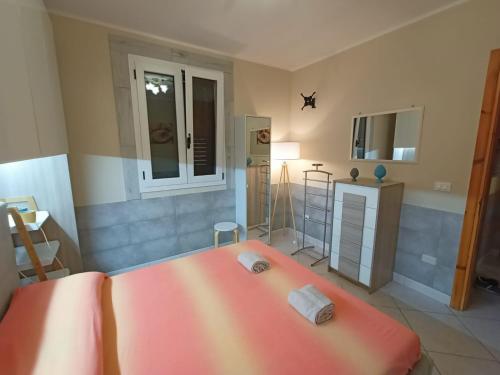 - une chambre avec un grand lit orange dans l'établissement Villetta "Poesia" a 50 m dal mare con giardino e parking, à Torre dell'Orso