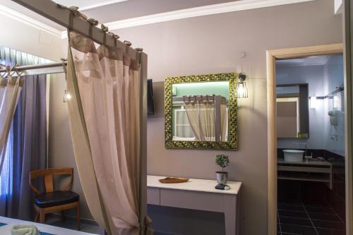 a bathroom with a mirror and a table and a chair at Elia Potie in Chania Town