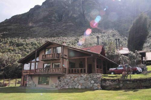 una casa en una colina con una montaña en el fondo en Hacienda Hostería Dos Chorreras en Cuenca