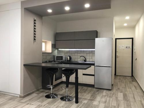 kuchnia z czarnym blatem i lodówką w obiekcie Sunrise Beach Apartment Trapani w Trapani