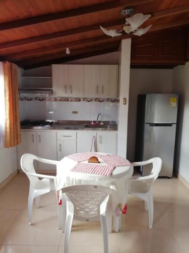 a kitchen with a table and chairs and a refrigerator at Hospedaje El Mirador in Iza