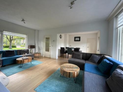 a living room with a blue couch and a table at HolidayHome Zonnestraal 9p Amsterdam and the beach in Heerhugowaard