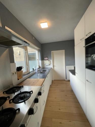 a kitchen with a stove and a sink at HolidayHome Zonnestraal 9p Amsterdam and the beach in Heerhugowaard