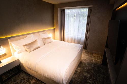 a bedroom with a large white bed with a window at HOTEL EUROPA in Komárno