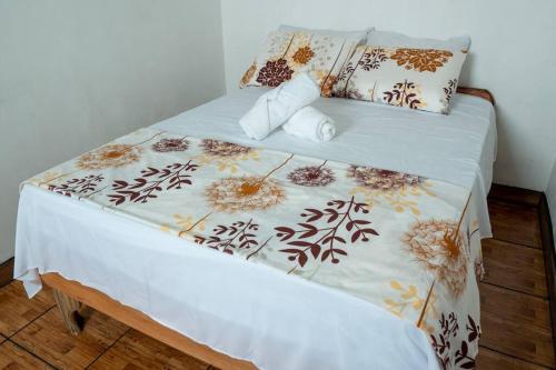 Una cama con una manta blanca y almohadas encima. en Tony's House, en Fortuna