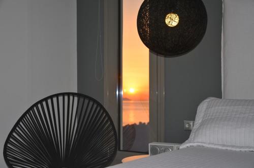 a bedroom with a bed and a fan and a window at Ino Hotel & Suites in Samos