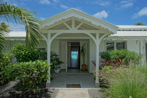 a white house with an arbor over the front door at Villa Liléa in Saint-François