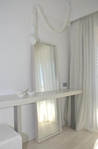 a white dressing table with a mirror in a room at Ino Hotel & Suites in Samos