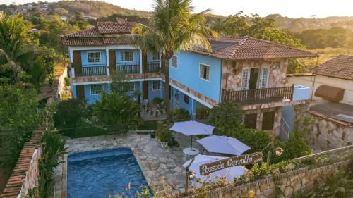 an aerial view of a house with a swimming pool and umbrellas at POUSADA CARVALHO in Pirenópolis