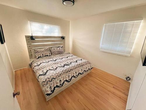 a bedroom with a bed and two windows at Pet Friendly! Private Casita in Nob Hill in Albuquerque
