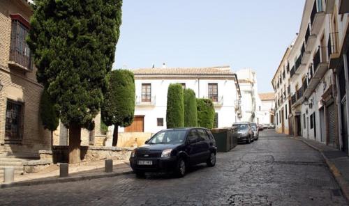 a black car parked on the side of a street at Hotel Plateros in Córdoba