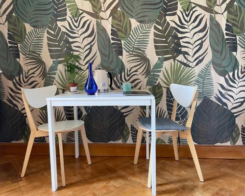 a table and two chairs in front of a wall at Le Beau Site Grand Hotel - lovely heritage cocoon Aix-les-Bains central park in Aix-les-Bains